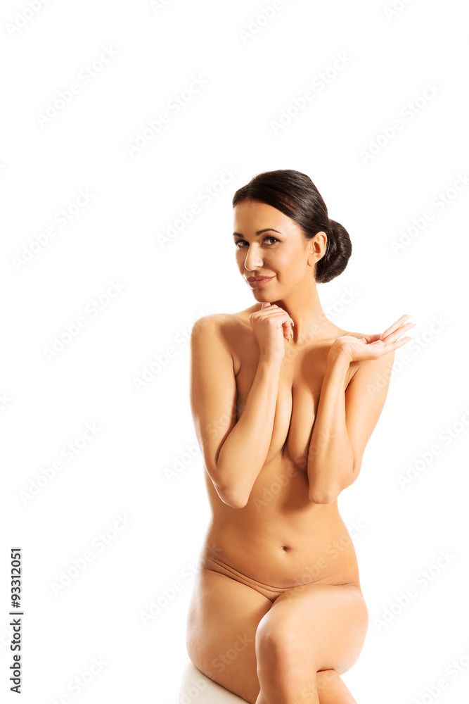 Nude woman sitting on desk, covering her breast Nude woman sitting on desk, covering her breast