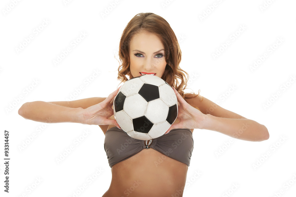 Woman in swimming bra with foot ball.