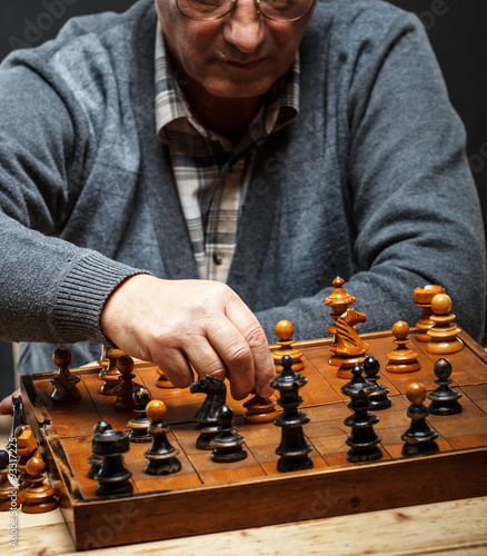 Senior man thinking about his next move in a game of chess