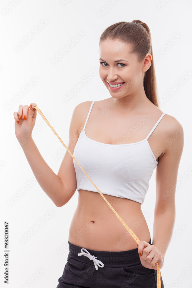 Attractive healthy fit woman is measuring her figure Attractive healthy fit woman is measuring her figure
