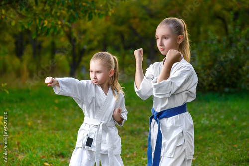girls in white kimono during training karate exercises at summer