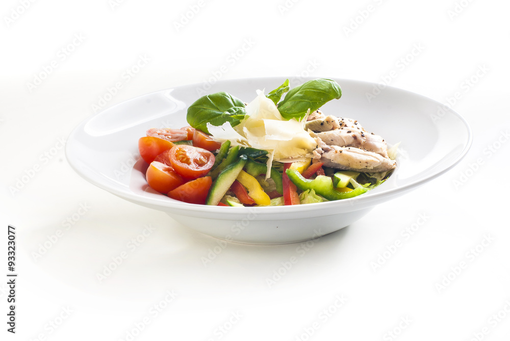 Salad with grilled chicken and vegetables on white background