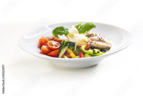 Salad with grilled chicken and vegetables on white background