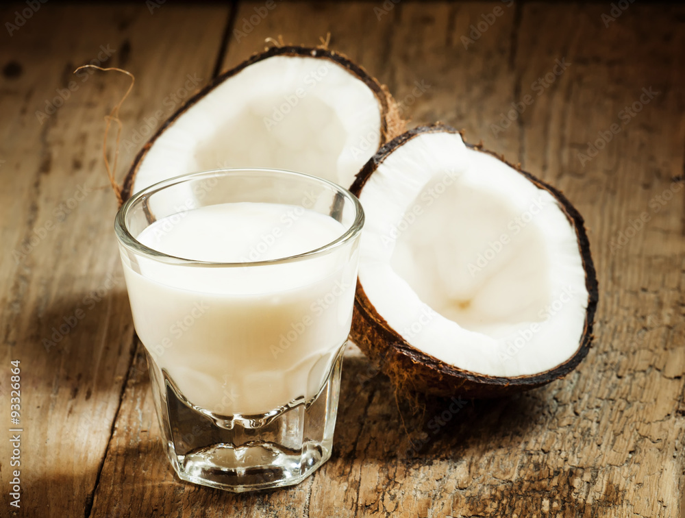 Coconut milk and fresh coconut on the old wooden background, sel Coconut milk and fresh coconut on the old wooden background, sel