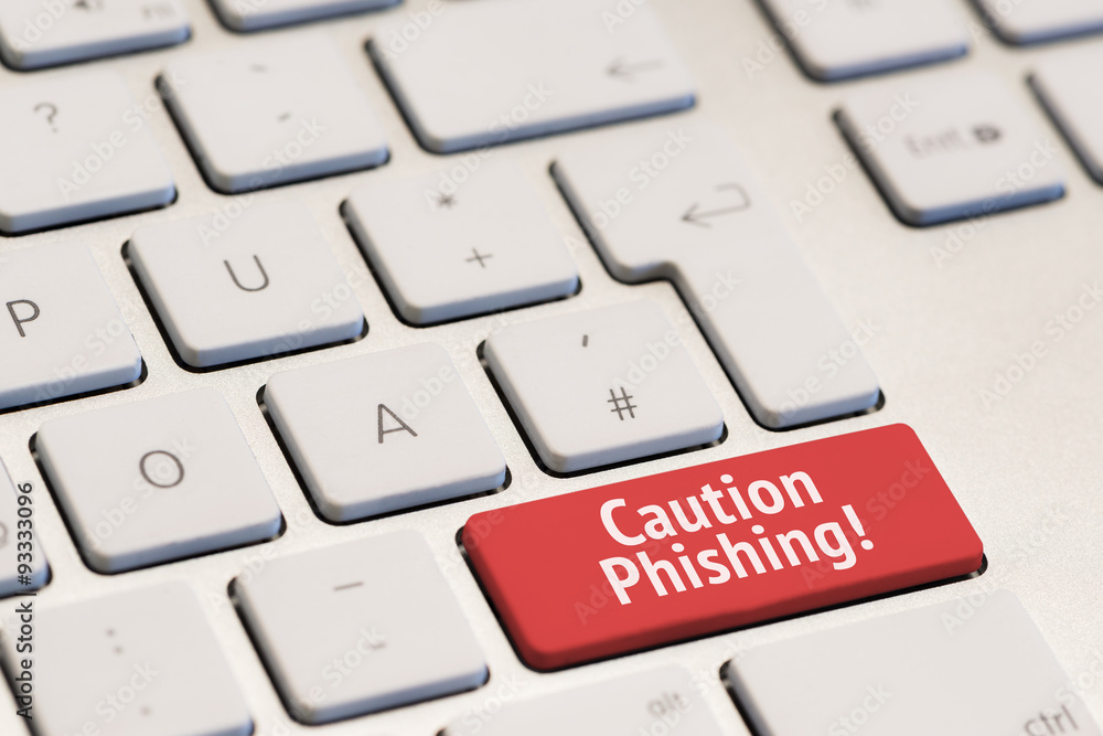 computer keyboard with the words caution phishing on red key computer keyboard with the words caution phishing on red key