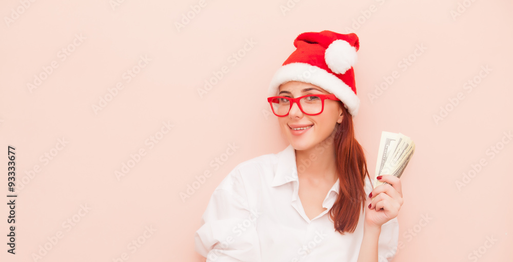 Fototapeta premium woman in Santa Claus hat with money