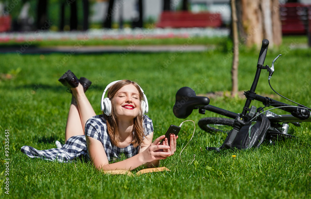 Young woman relaxing near bicycle in the park Young woman relaxing near bicycle in the park