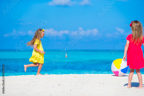 Little adorable girls playing on beach with air ball