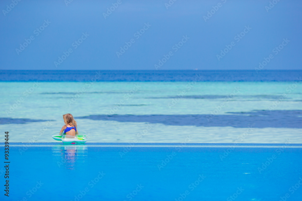 Obraz premium Little happy adorable girl in outdoor swimming pool