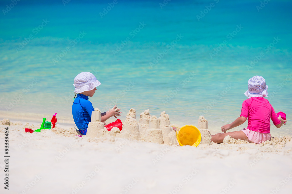 Adorable little girls playing with beach toys during tropical