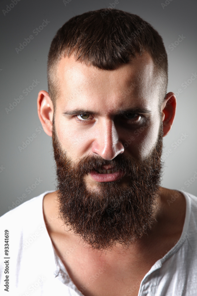 Portrait of handsome bearded man standing, isolated on grey Portrait of handsome bearded man standing, isolated on grey