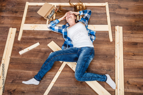 Happy woman having fun assembling furniture.