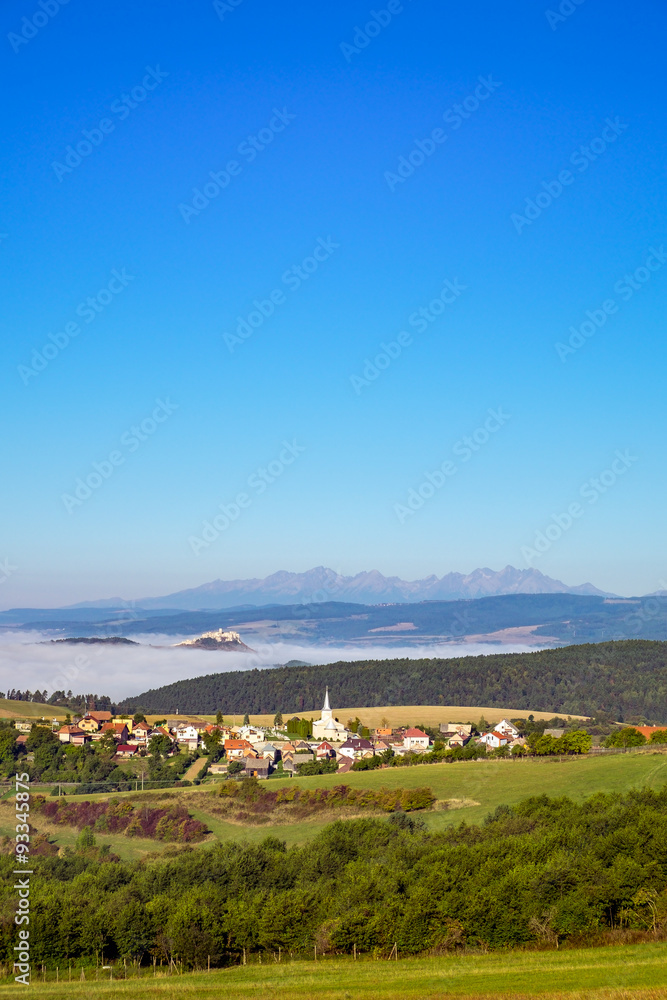 Scenic view of traditional village, castle, meadows and mountain