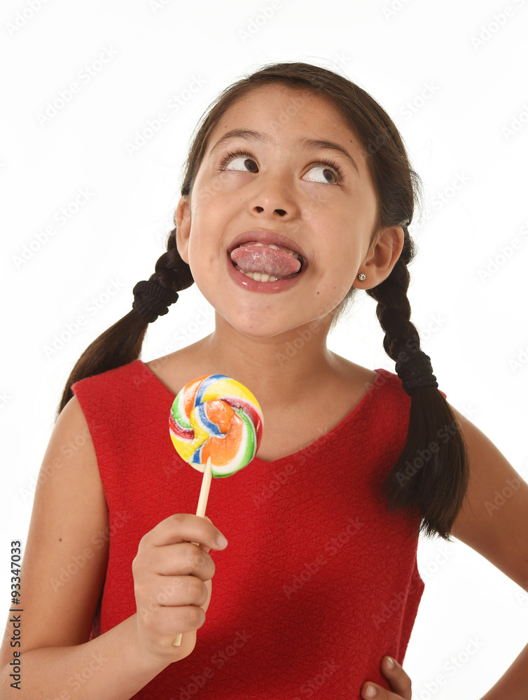 sweet beautiful latin female child holding lollipop candy with tongue out sweet beautiful latin female child holding lollipop candy with tongue out