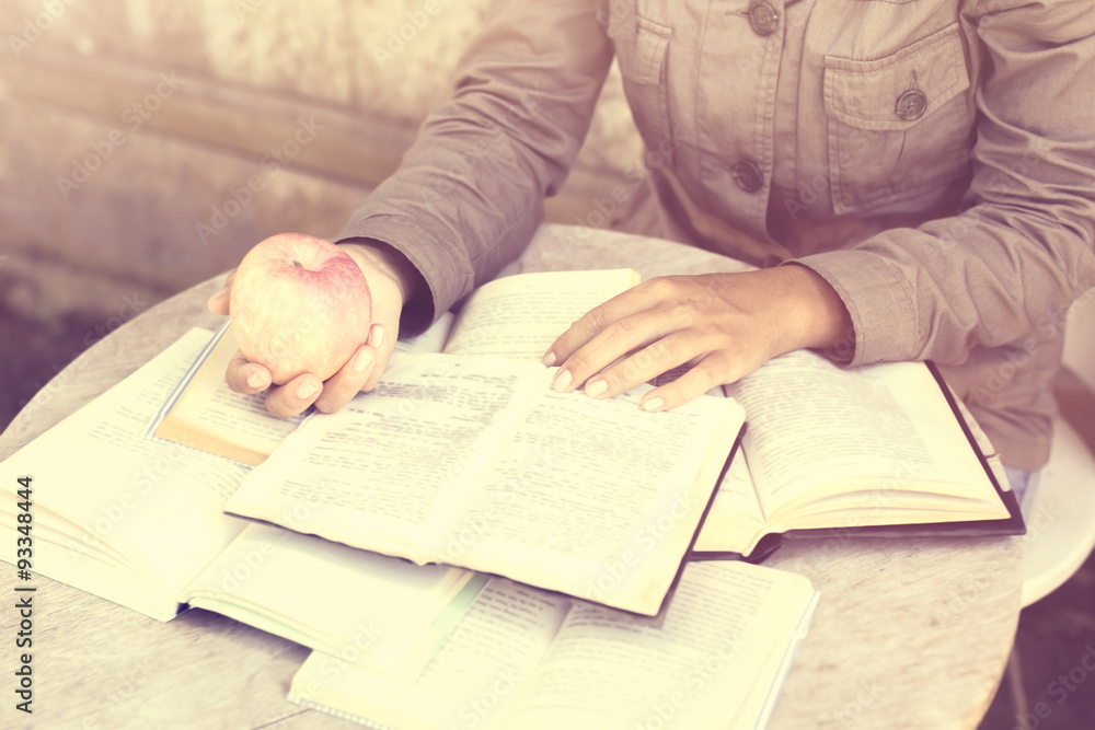 Girl with many open books on a table, vintage photo effect