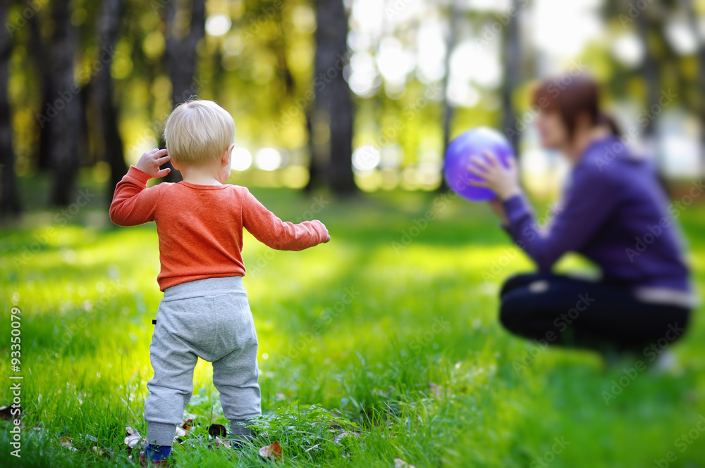Toddler with his mother playing with ball