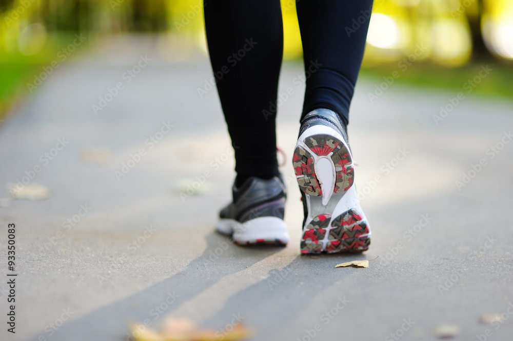 Runner feet running on road closeup on shoe Runner feet running on road closeup on shoe