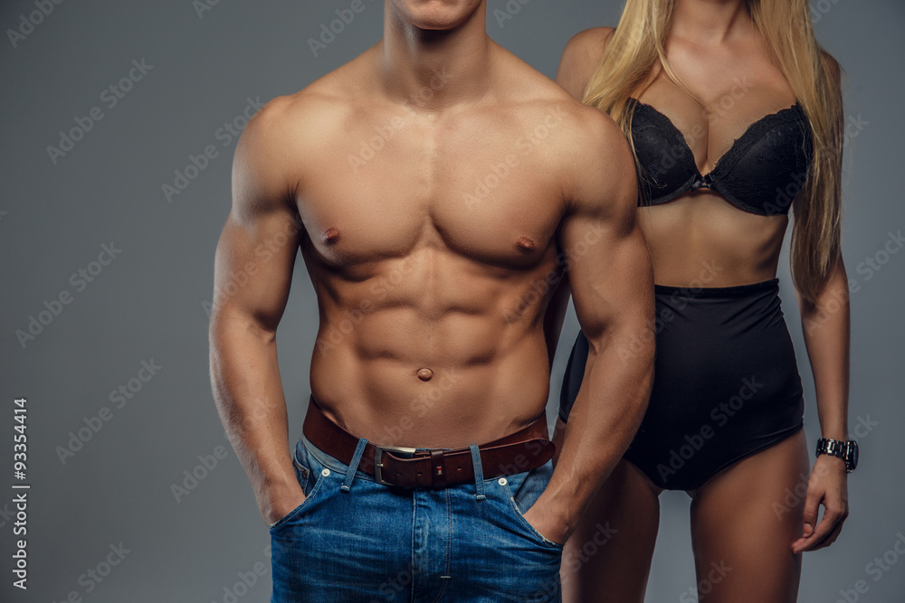 Shirtless muscular man and woman in black underwear.