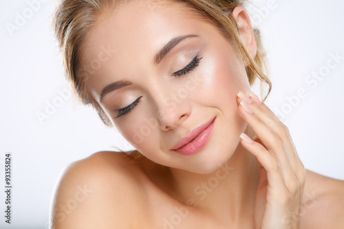 Young woman touching her face isolated on white background