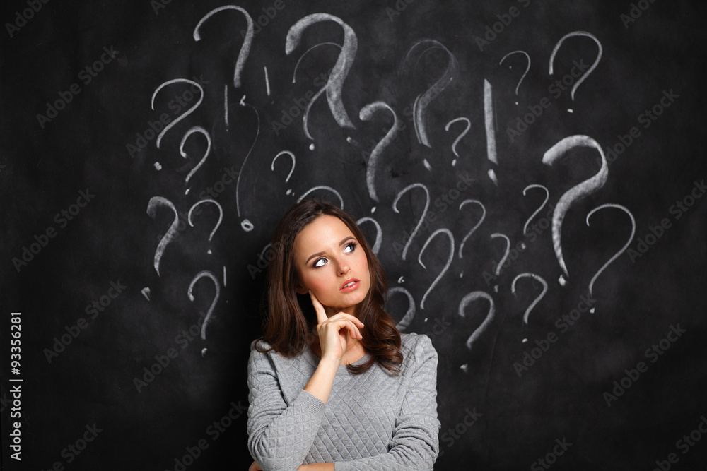 Young girl with question mark on a gray background Young girl with question mark on a gray background