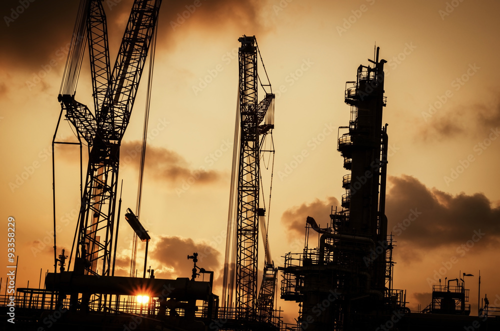 silhouette crane at petrochemical plant hot tone