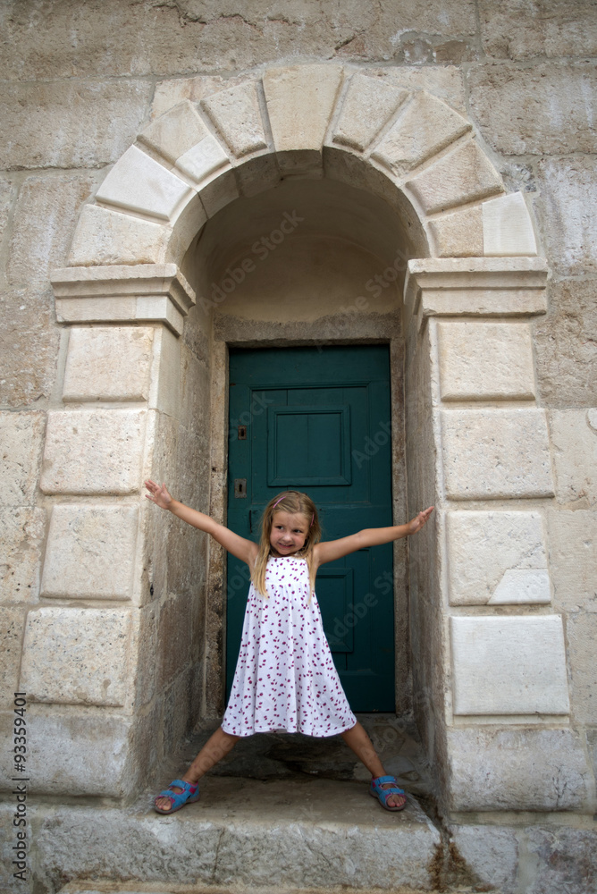 Little girl on old doors in Stari Grad, Hvar