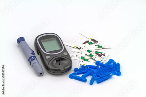 Many strip test of blood glucose meter, the blood sugar value is measured on a finger on white background photo