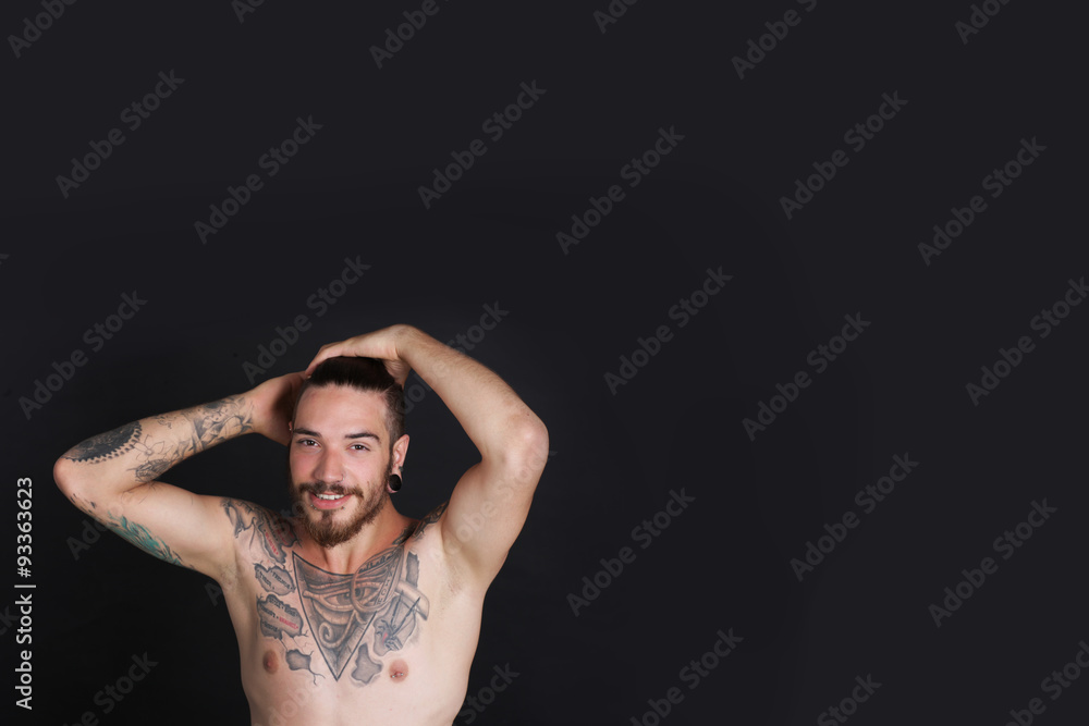 Young urban man with tattoos stripped to the waist Young urban man with tattoos stripped to the waist