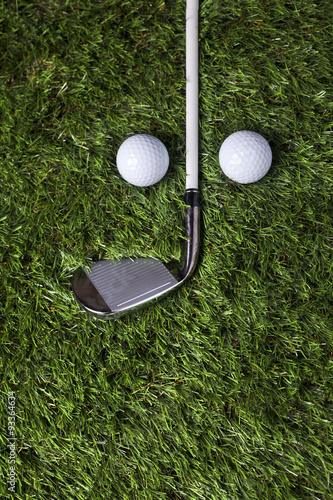 Golf club and balls on green grass