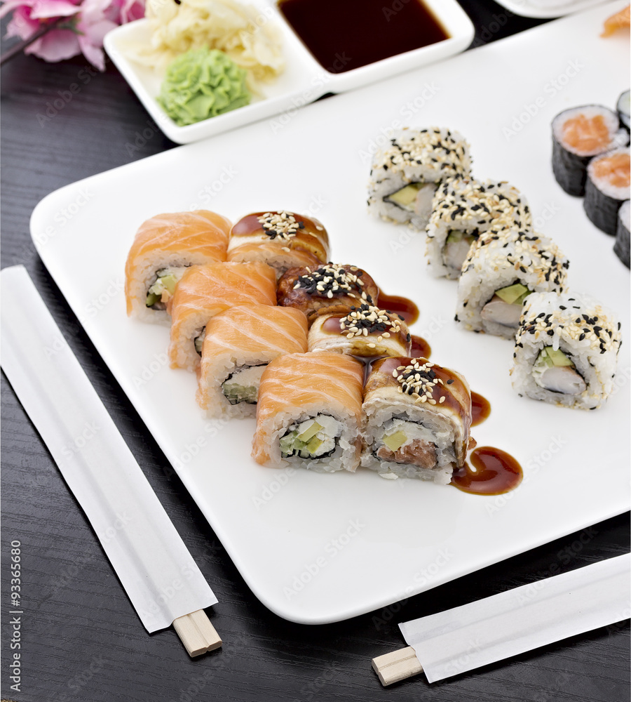 Sushi set with chopsticks and soy sauce over dark wooden background Sushi set with chopsticks and soy sauce over dark wooden background