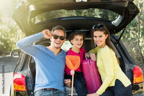 family sitting in the trunk of their car on a country road