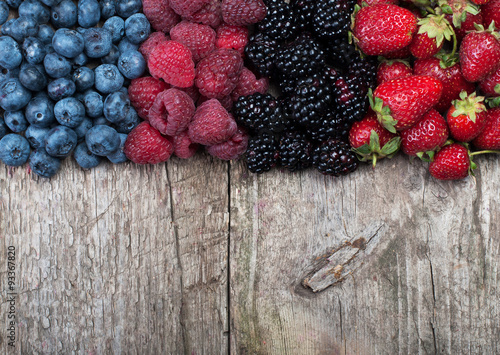 Different Fresh Berries on Wooden Background. Strawberries, Raspberries and Blueberries