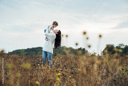 mother and daughter playing on autumn field together, loving family having fun outdoors © kurapatka