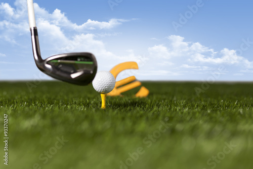 Targeting money with golf club and ball on green grass