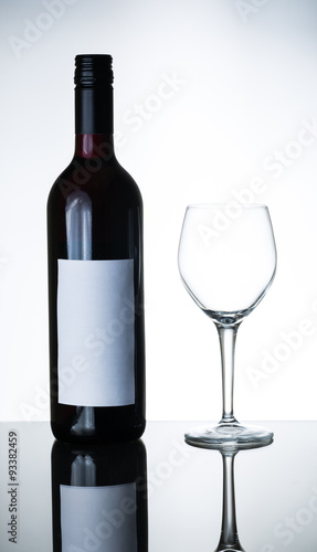 bottle of red wine and empty wine glass