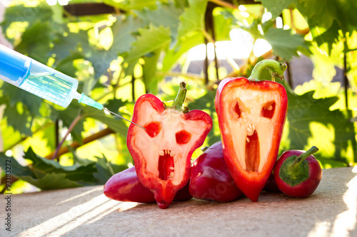 Foto bell pepper next to a syringe against