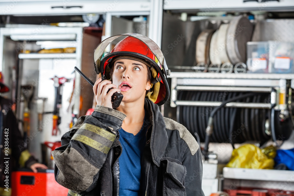Obraz premium Confident Female Firefighter Using Walkie Talkie