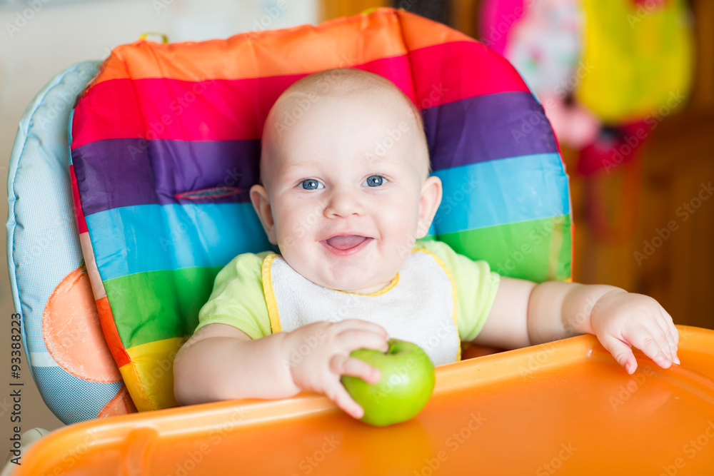 Adorable baby eating apple in high chair Adorable baby eating apple in high chair