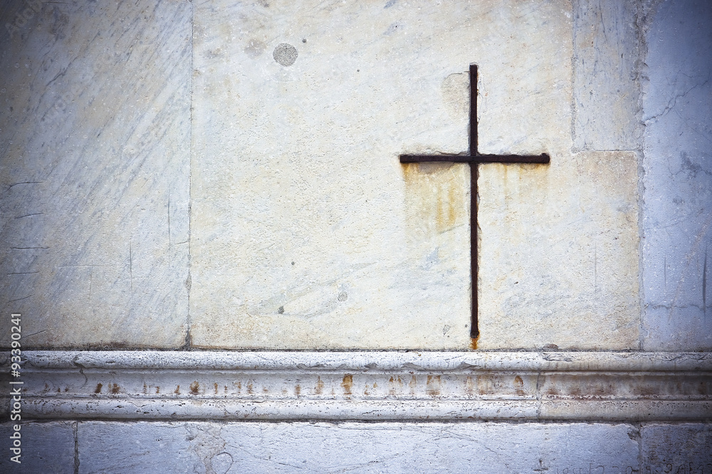 Iron cross snuggled in white stone on a italian facade church - image with copy space