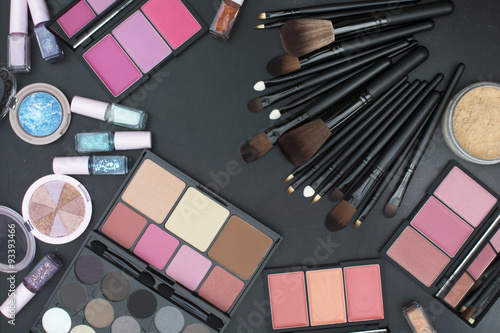 varsity size makeup brushes set with many tone of blushers,eyeshadows,highlighter,powder and nails paint on blackboard background