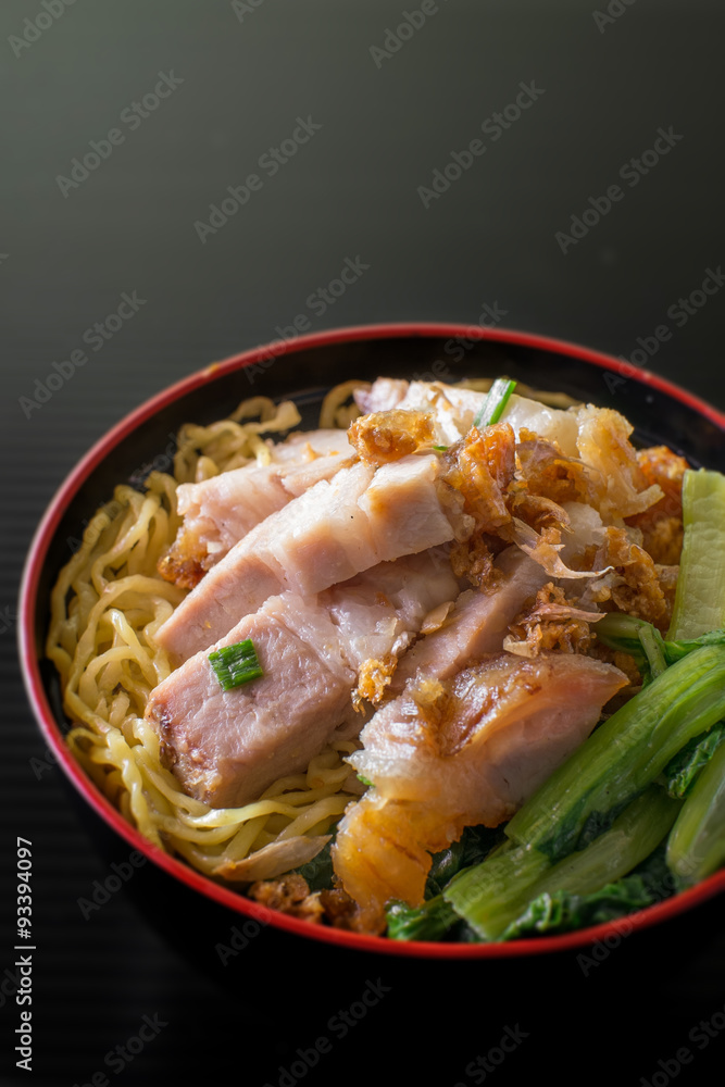 yellow noodle with crispy pork on black background yellow noodle with crispy pork on black background