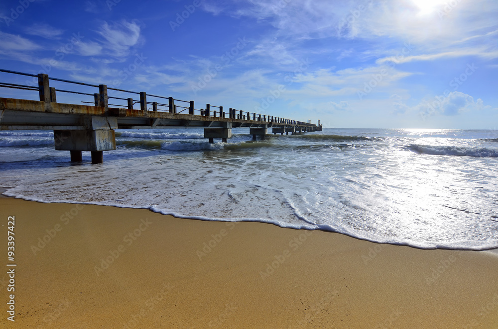 Fototapeta premium Weathered concrete breakwater with a rusty sheet pile and angled