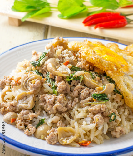 pork fried rice and fried egg with basil and chili background