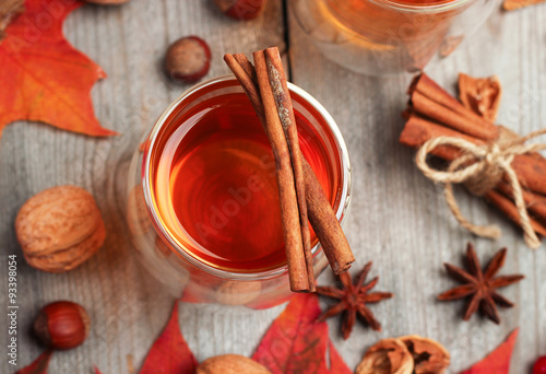 Autumn hot beverage in a glass with fruits and spices