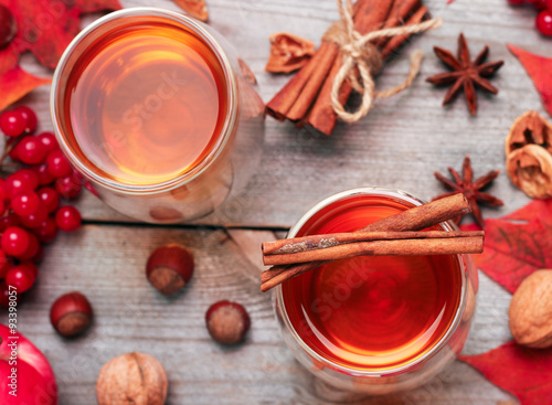 Autumn hot beverage in a glass with fruits and spices