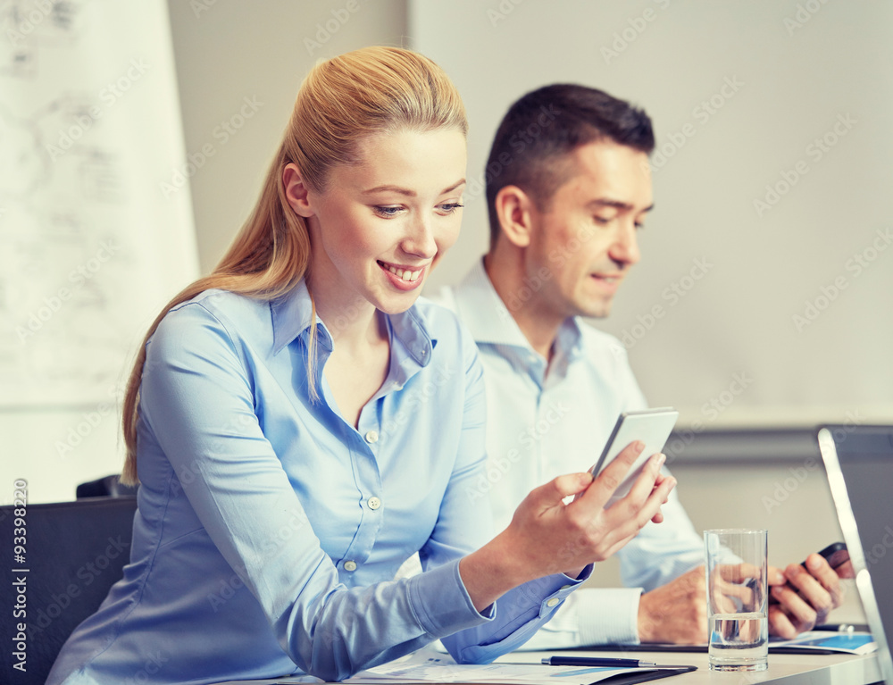 smiling businesspeople with smartphones in office smiling businesspeople with smartphones in office