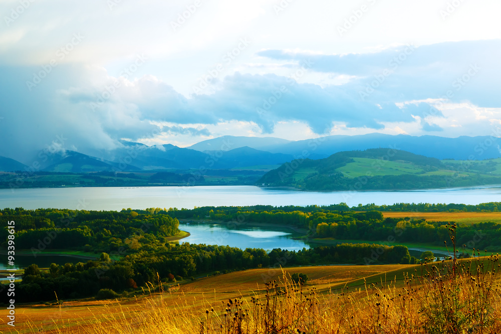 Beautiful landscape, yellow meadow and lake with mountains Beautiful landscape, yellow meadow and lake with mountains