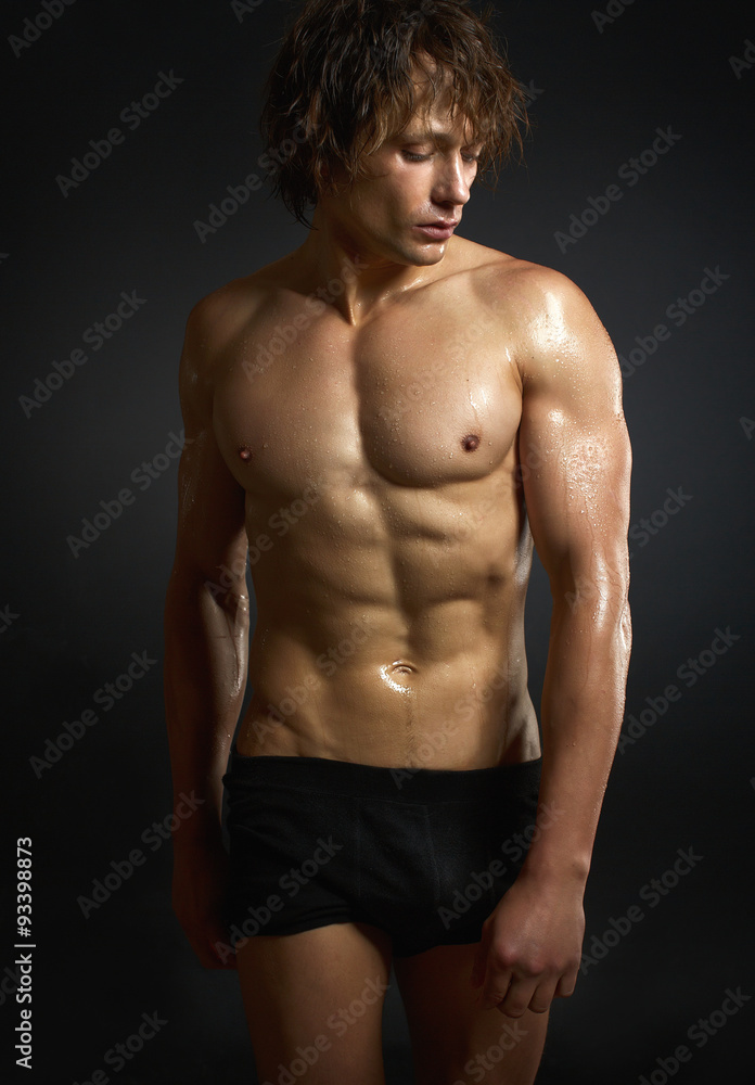 Naklejka premium Healthy muscular young man on black background.