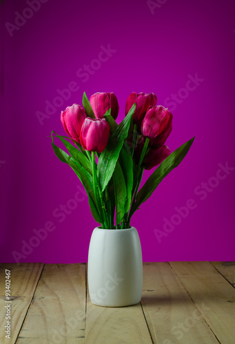 Fototapeta Naklejka Na Ścianę i Meble -  Red tulips in a vase pink background