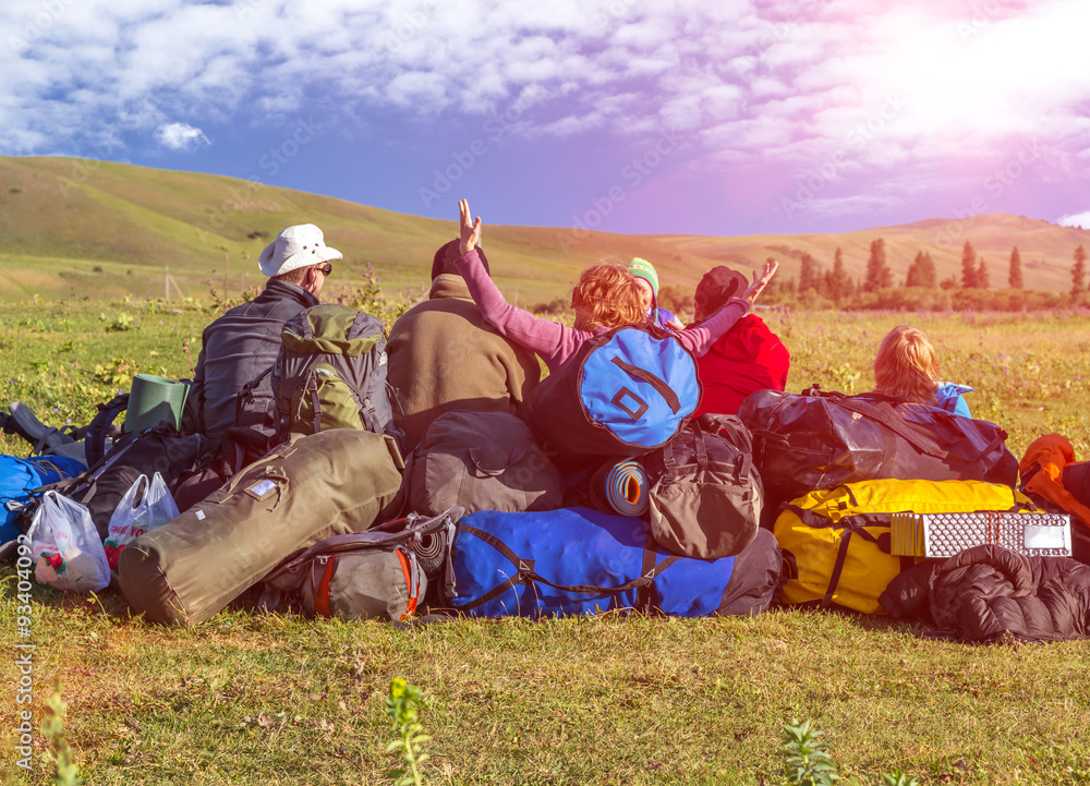 Φωτογραφία Jolly Company of Tourists Sitting on Large Heap of Travel Luggage on Green Meado